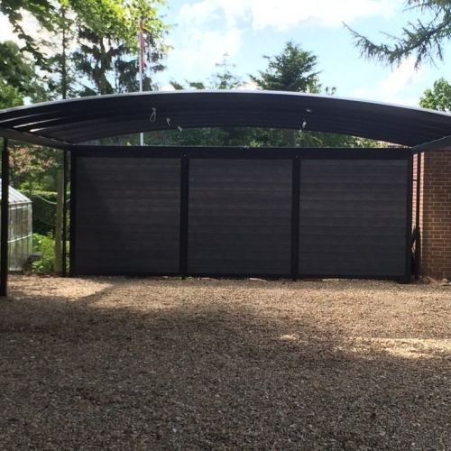 Sort dobbelt carport med vedligeholdelsesfri beklædning og buet tagform