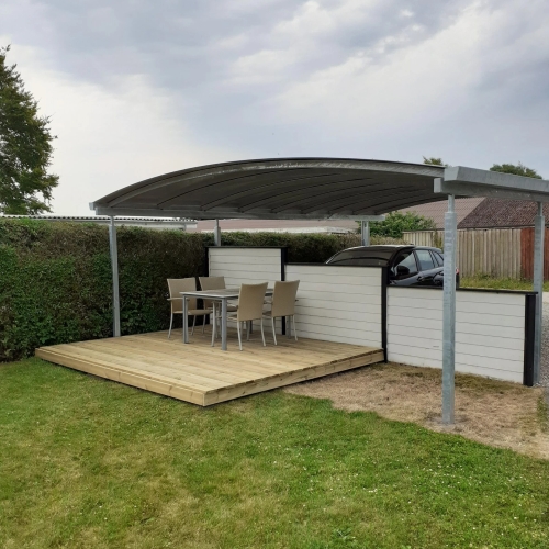 Dobbelt carport med overdækket terrasse og træterrasse i haven