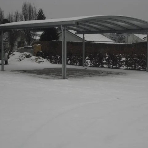 Dobbelt carport med transparent tag i vintermiljø