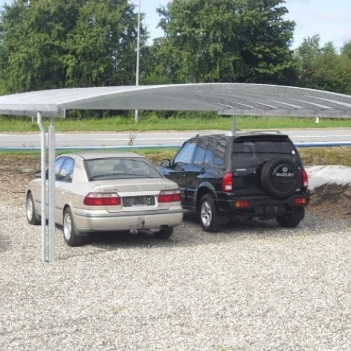 Dobbelt carport i stål på grusbelagt parkeringsområde