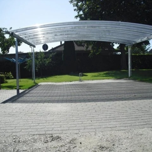 Fritstående dobbelt carport med buet tag i haven