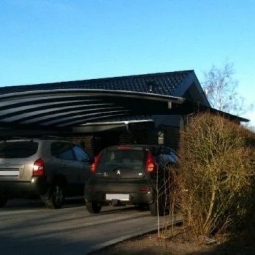 Sort dobbelt carport med plads til to biler ved villa