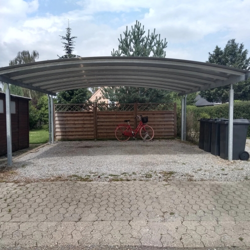 Fritstående dobbelt carport på grusbelagt indkørsel