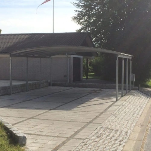 Dobbelt carport med buet tag og stor belagt indkørsel i Sindal