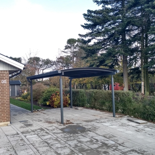 Enkelt carport ved murstensvilla
