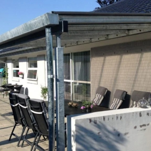 Terrasseoverdækning med spiseplads langs husets facade
