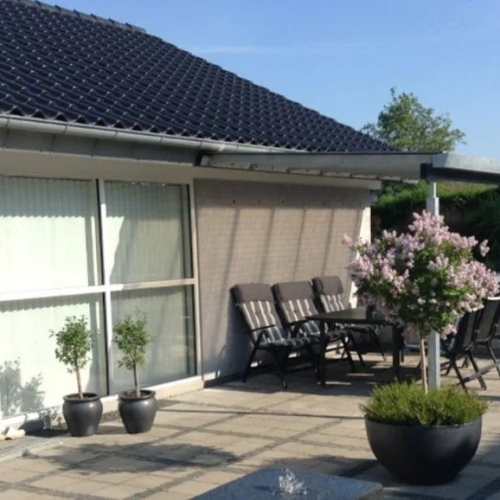Terrasseoverdækning ved moderne villa med fliseterrasse