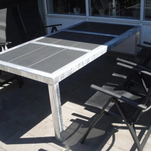 Terrasseoverdækning med spisebord og havestole på fliseterrasse