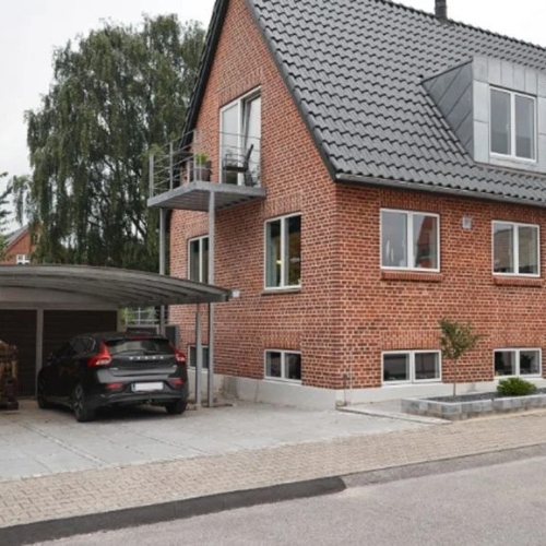 Carport med skur og brændeopbevaring ved murstensvilla.