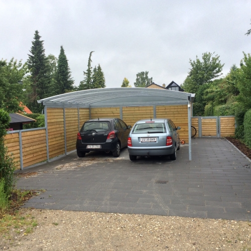 Dobbelt carport med skur og træbeklædte sidevægge til to biler i Brønshøj.