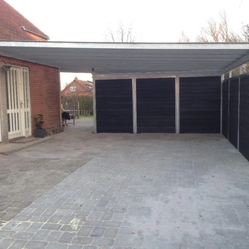 Carport med skur i sort træ og galvaniseret stål ved murstenshus i Horsens.