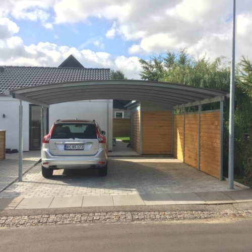 Carport med skur og træbeklædte sider ved indkørsel med bil i Hvidovre.