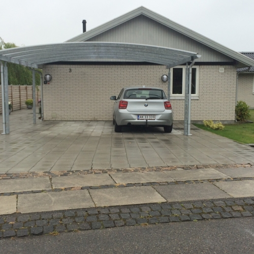 Moderne dobbelt carport med plads til to biler på flisebelægning