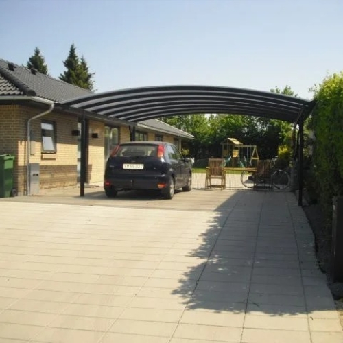 Dobbelt carport med buet tag ved moderne parcelhus