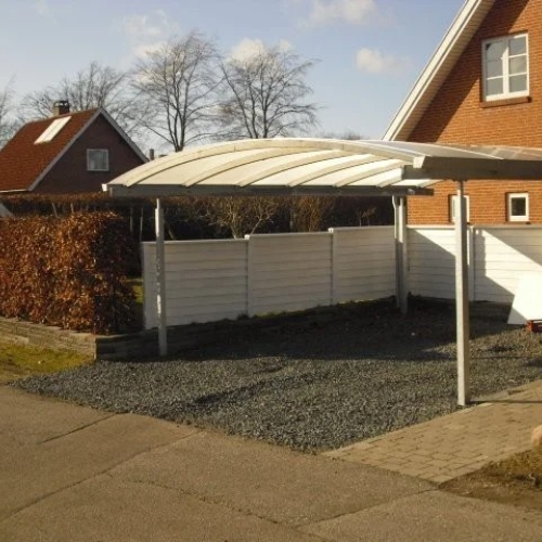Fritstående dobbelt carport med transparent tag og grusbund