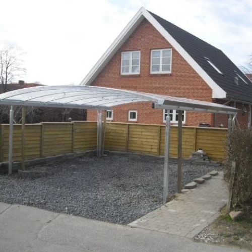 Moderne dobbelt carport med buet tag ved villa
