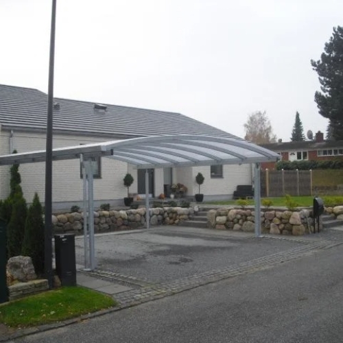 Dobbelt carport med buet tag ved moderne villa