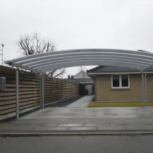 Fritstående dobbelt carport med transparent tag og grusbelægning