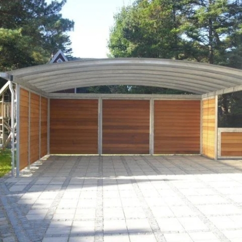 Dobbelt carport med træbeklædte sidevægge og buet tag