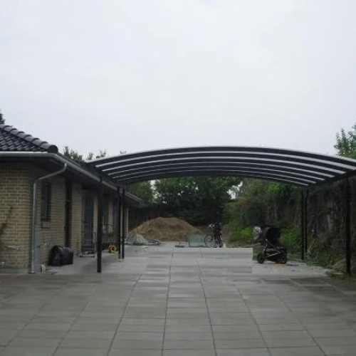 Sort dobbelt carport med ekstra bredde på flisebelagt indkørsel