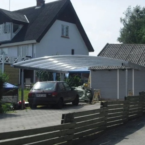 Rummelig dobbelt carport med transparent tag ved villa