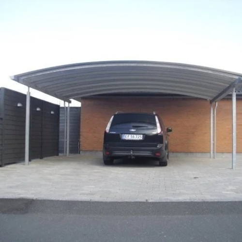Dobbelt carport med plads til to biler foran murstenshus