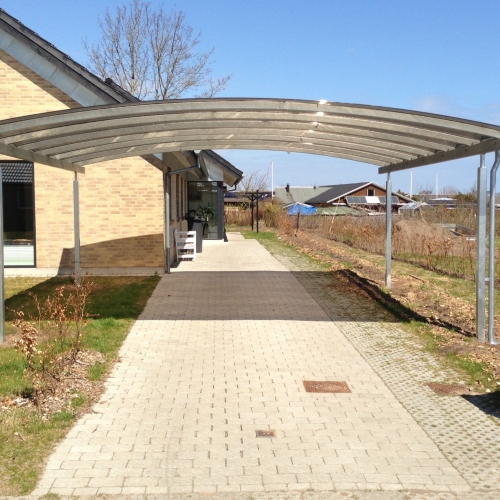 Dobbelt carport med buet tag ved moderne villa i Sæby