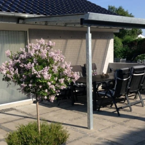 Terrasseoverdækning med spisebord og blomstrende have