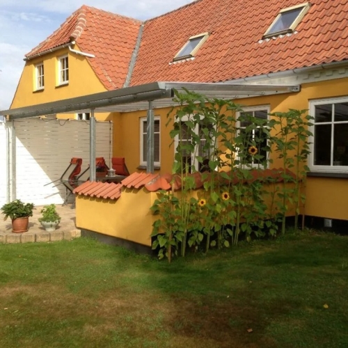 Terrasseoverdækning ved gul villa med afskærmet opholdsområde i Randers