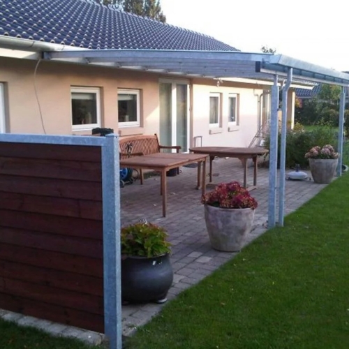 Terrasseoverdækning langs hus med afskærmet terrasseområde
