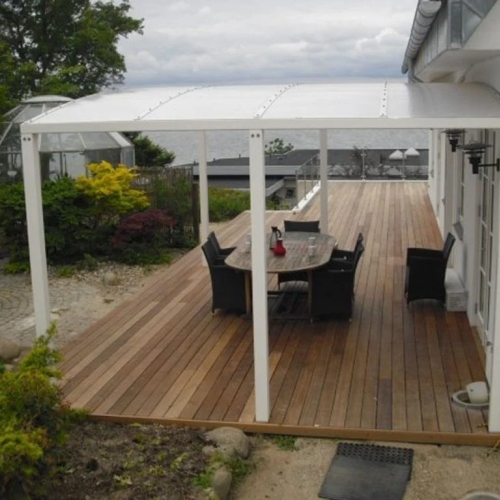 Terrasseoverdækning med spiseplads ved villa og træterrasse