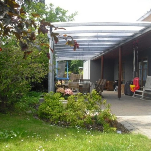 Lang terrasseoverdækning langs hus med haveudsigt