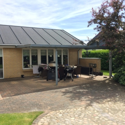 Terrasseoverdækning ved villa med stor fliseterrasse